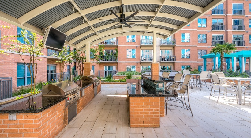 Poolside grilling station and lush landscaping and covered area